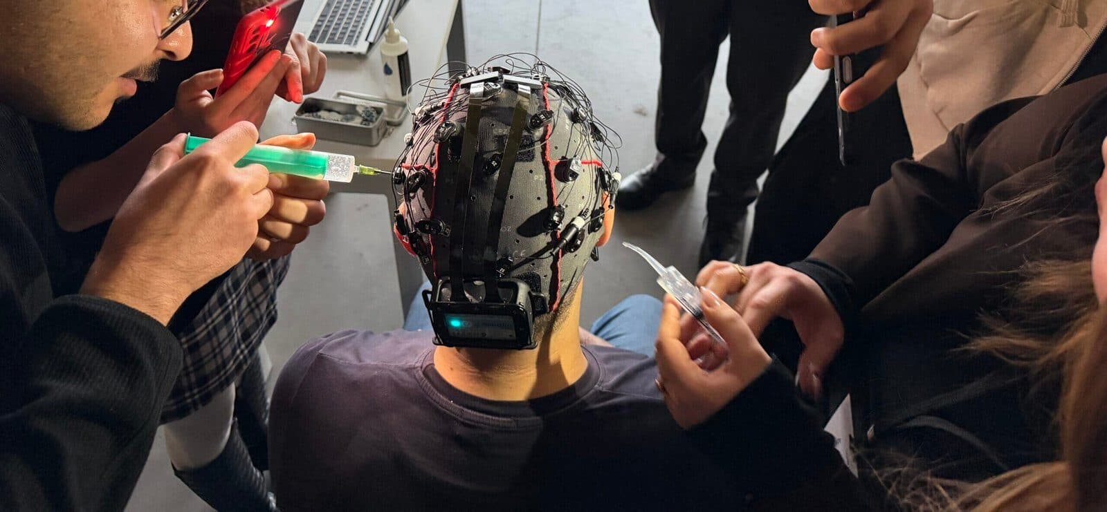 NeuroTech University Tour'da katılımcılar jel elektrotlu bir EEG başlığını hazırlıyor